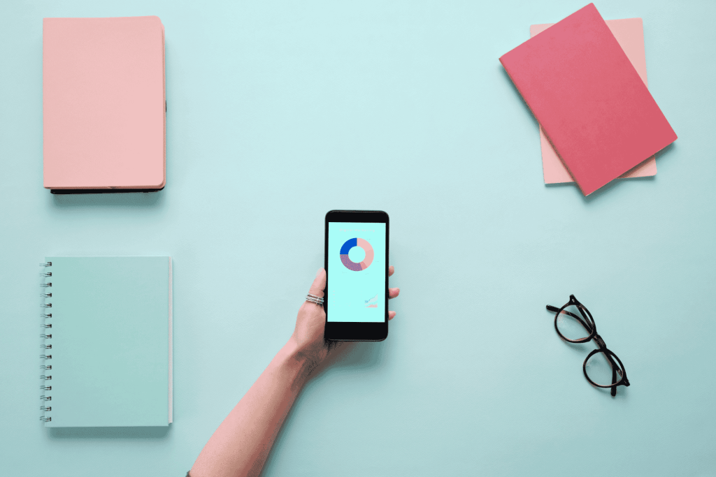 splash art of phone with data on screen on a flat lay desk with notebooks 1